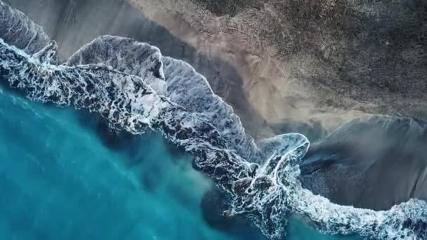 Blick von oben auf einen einsamen schwarzen Vulkanstrand. Küste der Insel Teneriffa. Drohnenaufnahmen von Meereswellen, die die Küste erreichen - Filmmaterial, Video