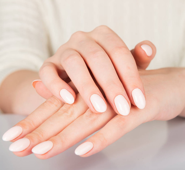 Beautiful female hand with beige nail design - Foto, Imagen