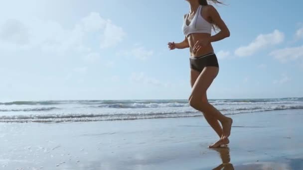 Femme coureuse de fitness courir sur la plage en écoutant la motivation musicale avec étui de téléphone brassard sport sangle. Athlète sportif entraînement cardio pieds nus avec détermination sous le soleil d'été. - Séquence, vidéo