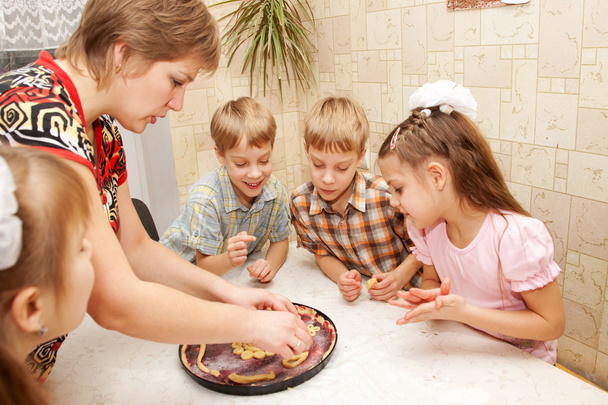 grote en gelukkige familie koken een taart samen. - Foto, afbeelding