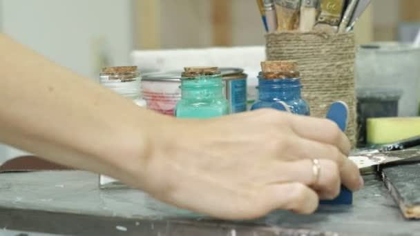 Mains de doigté le pot et les bouteilles de peinture, choisir la bonne couleur dans les vases
 - Séquence, vidéo