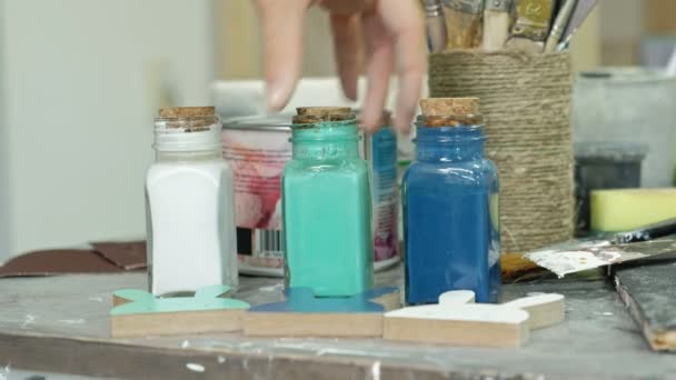 Mains de doigté le pot et les bouteilles de peinture, choisir la bonne couleur dans les vases
 - Séquence, vidéo