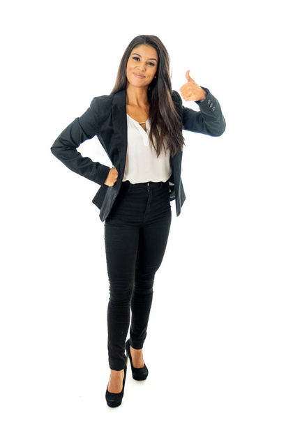 Full length portrait of a beautiful latin businesswoman smiling and making thumbs up sign standing isolated on a white background. - Foto, afbeelding
