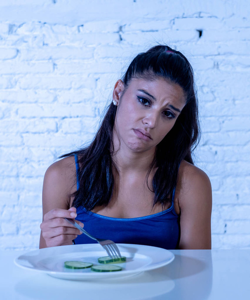 Portrait o f young attractive woman feeling sad and bored with diet not wanting to eat vegetables or healthy food in Dieting Eating Disorders and weight loss concept. - Foto, immagini