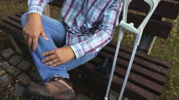 Disabled man massages leg muscle - Кадры, видео