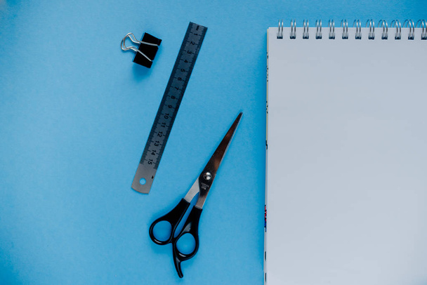 education concept orange pencils, sketchbook , scisots, puncher. Educational set on blue background. - Valokuva, kuva
