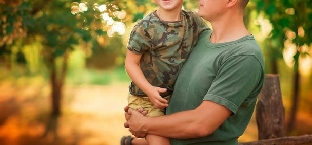 Portrait of happy son embracing a soldier - Zdjęcie, obraz