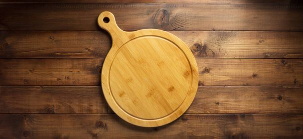 pizza or bread cutting board at wooden table, top view - Foto, immagini