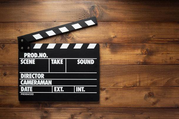 movie clapper board at wooden background texture, top view - Foto, afbeelding