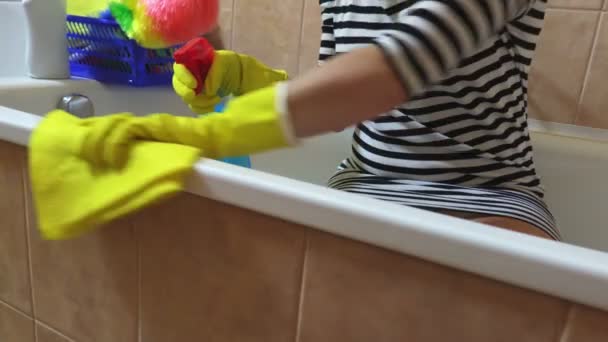 Mujer con trapo amarillo puliendo el borde del baño
 - Imágenes, Vídeo