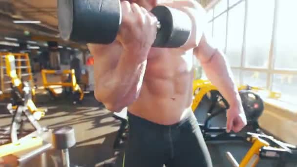 Bodybuilder im schwarzen Tanktop, der seinen Schultermuskel pumpt - Filmmaterial, Video