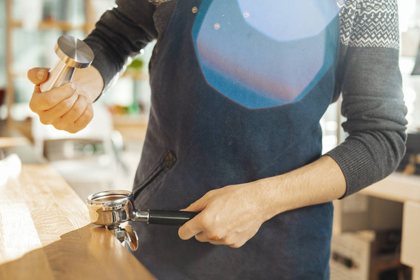 Close up of barista with tamper and piston or portafilter making espresso. - Photo, Image