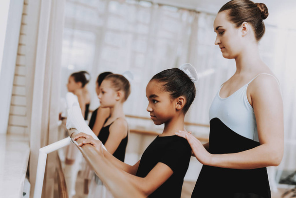 Ballet Training of Group of Girls with Teacher. Classical Ballet. Girl in Balerina Tutu. Training Indoor. Cute Dancers. Performance in Hall. Dancing Practice. Girls in White Dresses. - Foto, afbeelding