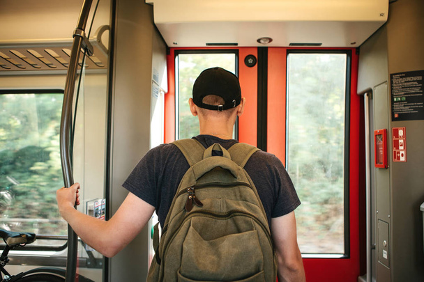 Turista o studente con uno zaino in attesa che il treno si fermi
 - Foto, immagini