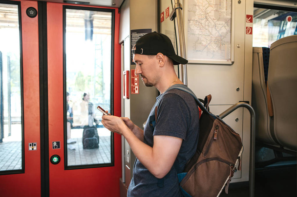 Un turista sul treno utilizza un telefono cellulare
. - Foto, immagini