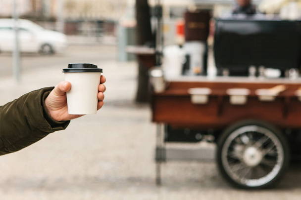 Osoba trzyma kieliszek jednorazowe w ręku z kawą lub inny gorący napój. - Zdjęcie, obraz