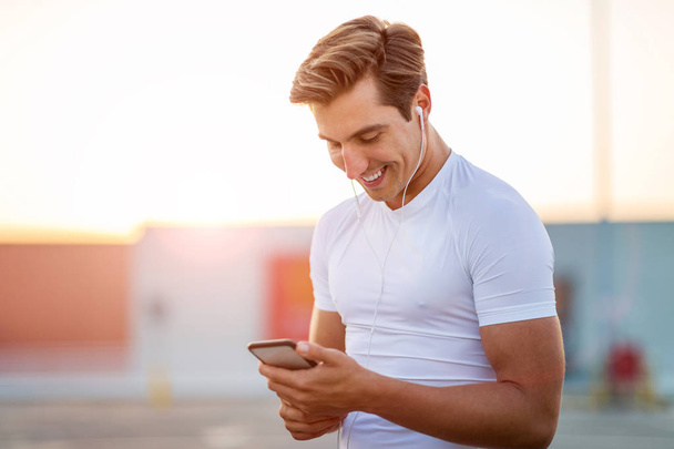 Şehrin smartphone ile sportif genç adam - Fotoğraf, Görsel