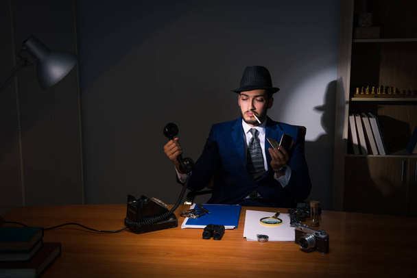 Детектив сидит в темной комнате в винтажной концепции - Фото, изображение