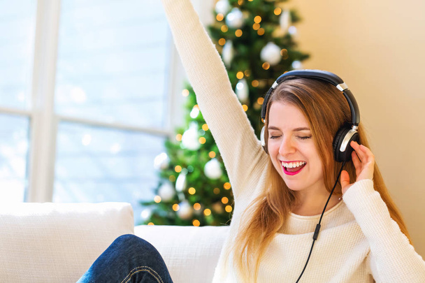 Happy young woman listening to music on headphones - Photo, Image