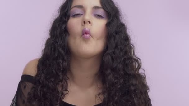 black curly hair plus size model with brown eyes on lilac background with lilac makeup - Imágenes, Vídeo