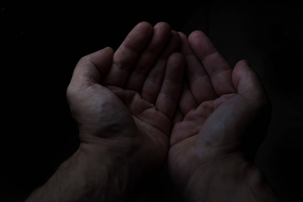 Duas mãos de homem em fundo preto
 - Foto, Imagem