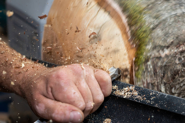 wood sawdust shavings squirting while creating timber bowl on turnery - 写真・画像