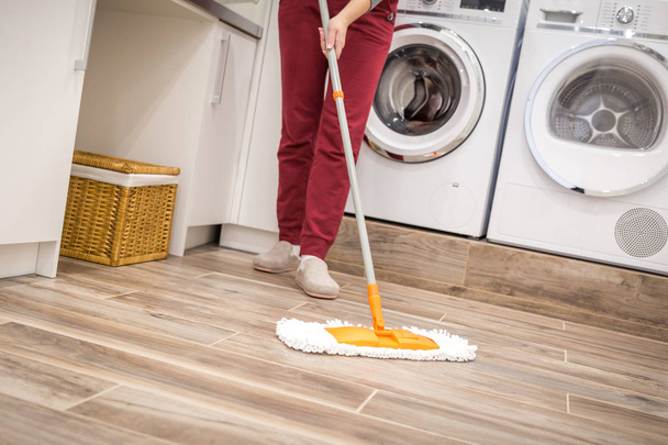 Καθαρίζοντας πάτωμα στο δωμάτιο πλυντηρίων - Φωτογραφία, εικόνα