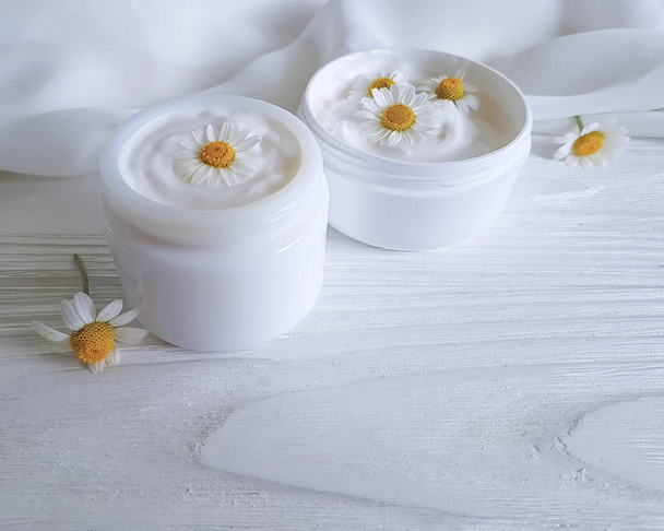 crema cosmetica fiore margherita su sfondo bianco in legno
 - Foto, immagini