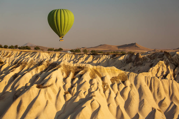 Beautiful landscape of Cappadocia valley with hot air balloons in background at sunrise - Photo, Image