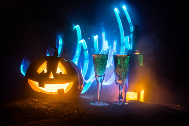 Fête du vin d'Halloween thème. Deux verres de vin et une bouteille avec Halloween - vieux Jack-o-lanterne sur fond sombre et brumeux. effrayant Halloween citrouille
 - Photo, image