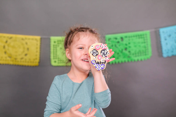 Malá holčička zdobení cukroví s royal poleva pro Dia de los Muertos dovolenou. - Fotografie, Obrázek
