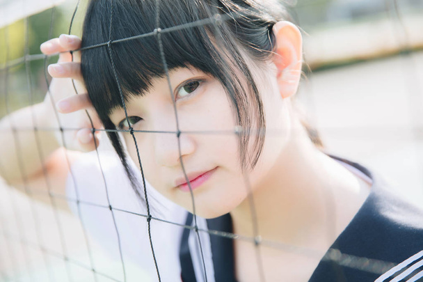 Retrato de belo asiático japonês menina do ensino médio uniforme olhando com rede em fundo verde - Foto, Imagem