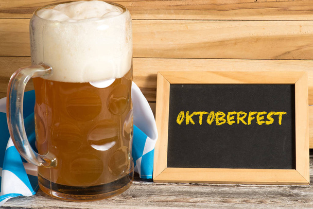 Een glas bier en een bord met het woord Oktoberfest - Foto, afbeelding