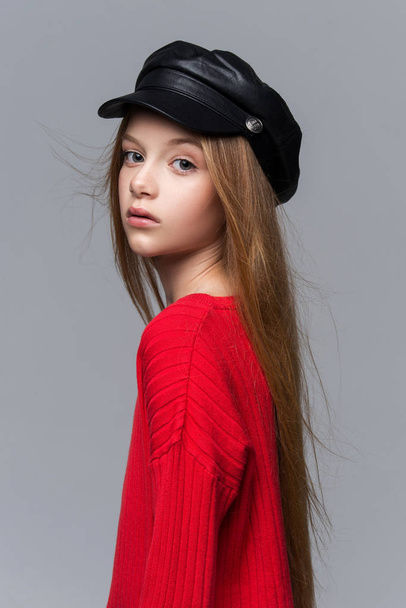 Close-up portrait of beautiful young redhead girl wearing red sweater posing in studio - Fotó, kép
