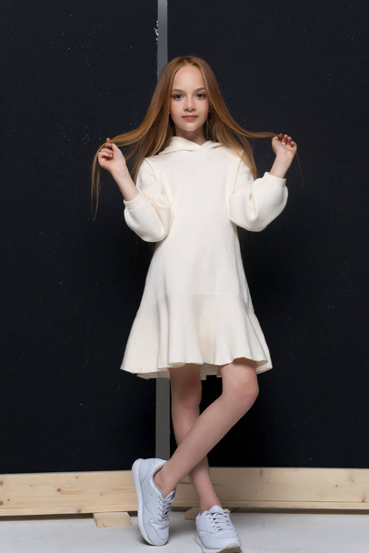Portrait of beautiful young redhead girl posing in studio - 写真・画像