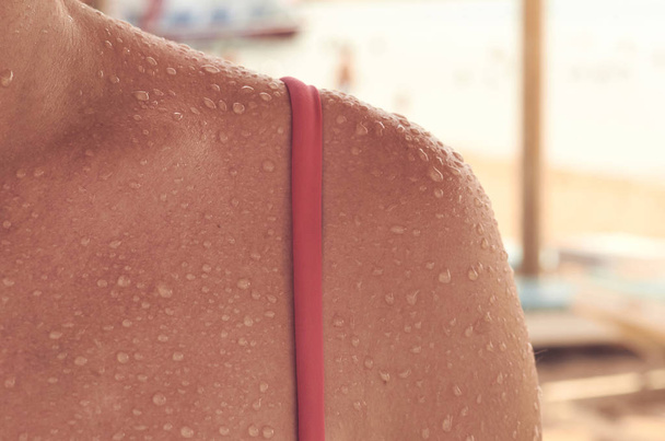 texture and water droplets on the girl body, pink swimsuit. - Фото, изображение
