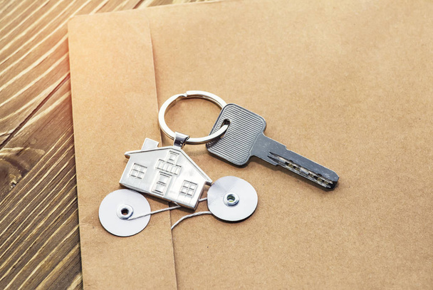 Schlüsselanhänger mit Haussymbol und Schlüssel, Immobilienkonzept - Foto, Bild