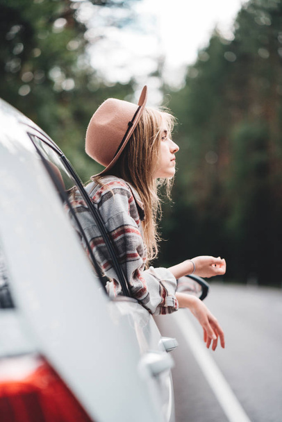 Hipster szczęśliwy dziewczyna podróży wakacje przygoda. Boho kobieta siedzi w samochodzie, patrząc z okna na piękny widok w kraju road - Zdjęcie, obraz