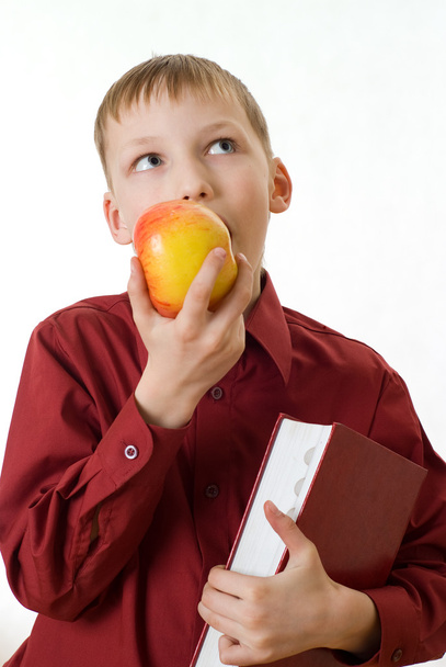 Boy in a red shirt eating an apple - Фото, зображення