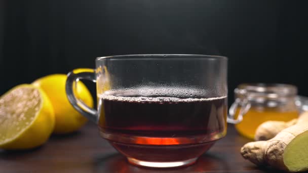 Milk is added to the black tea in glass cup, making of english tea, hot drink - Footage, Video