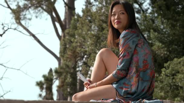 Beautiful asian young woman in the park. Relax,sun,nature - Video