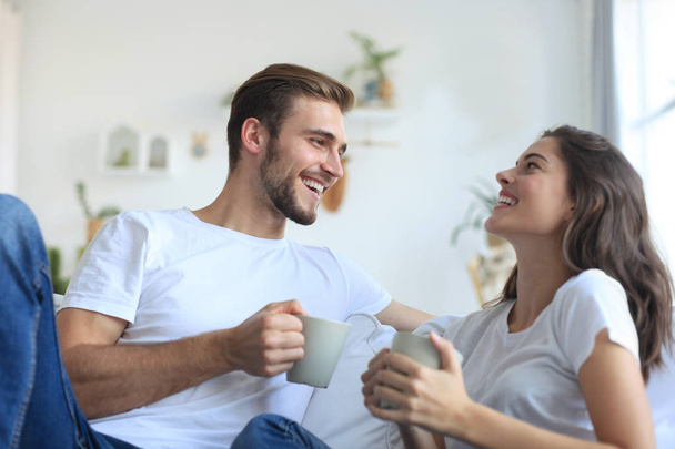 Cheerful young couple in the morning at home in the living room. - Photo, Image