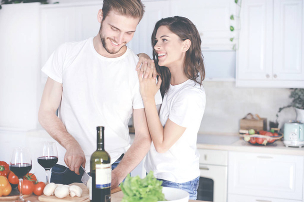 Beautiful young couple preparing a healthy meal together while spending free time at home. - Photo, Image