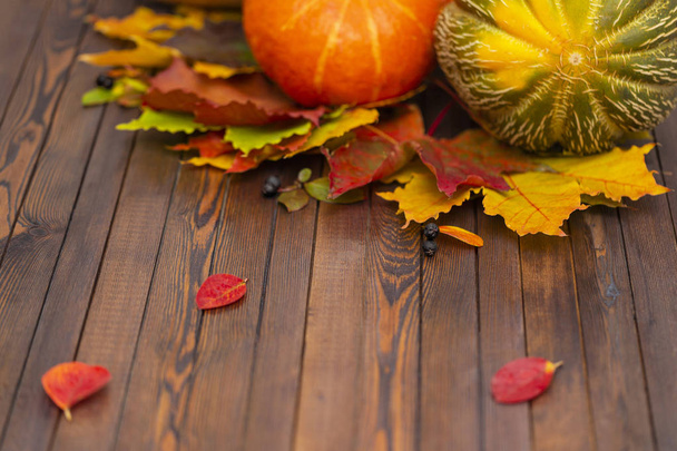 Hálaadás háttér. Őszi zöldségek, bogyók és levelek egy fából készült hajón. A koncepció a Hálaadás. - Fotó, kép