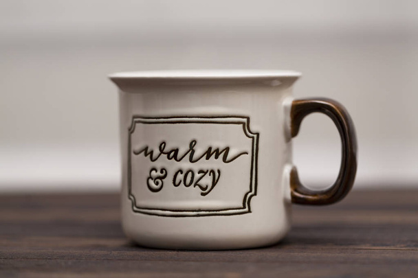 Cocoa with marshmallows on a wooden background in a Cup with the inscription " Warm and cozy" - Foto, imagen