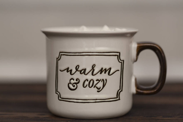 Cocoa with marshmallows on a wooden background in a Cup with the inscription " Warm and cozy" - Foto, imagen