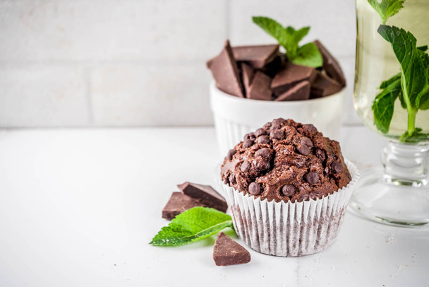 Huis gebakken mint en chocolade muffins met mint thee, witte marmeren achtergrond kopie ruimte - Foto, afbeelding