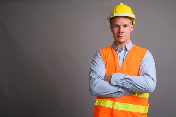 Ember építőmunkás sötétszürke háttérrel portréja - Fotó, kép