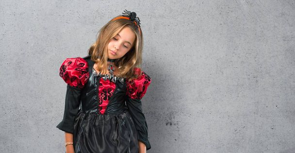 Blonde child dressed as a vampire for halloween holidays unhappy and frustrated with something. Negative facial expression on textured background - 写真・画像