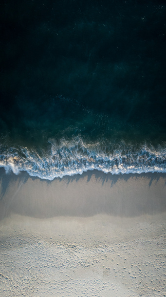 a légi felvétel a tenger partján homokos strand és a kék hullámok  - Fotó, kép
